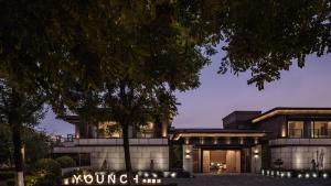 西安西安央辰酒店 Younch Hotel Xi'an的前面有一棵树的建筑物