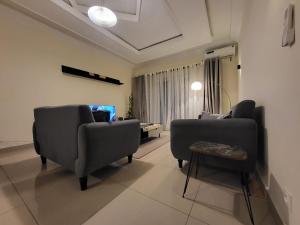 a living room with chairs and a table at Chez Nous in Pointe-Noire
