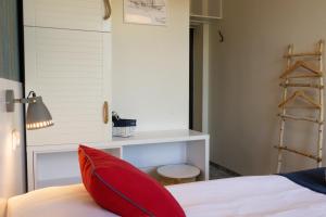 a bedroom with a red pillow on a bed at SeaSide Sopot - butikowe noclegi przy plaży in Sopot