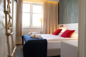 a bedroom with a bed with red pillows and a window at SeaSide Sopot - butikowe noclegi przy plaży in Sopot
