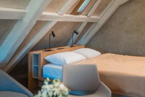 ein Dachzimmer mit zwei Betten und einem Laptop in der Unterkunft Granarium in Ilok