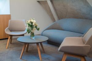 ein Zimmer mit einer Couch und einer Blumenvase auf einem Tisch in der Unterkunft Granarium in Ilok