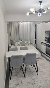 ein Schlafzimmer mit einem großen Bett und zwei Stühlen in der Unterkunft Уютный Дом in Chişinău