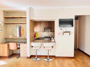 a kitchen with two bar stools and a tv at TAG@12A in Piet Retief