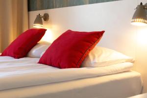 a bedroom with red pillows on a white bed at SeaSide Sopot - butikowe noclegi przy plaży in Sopot