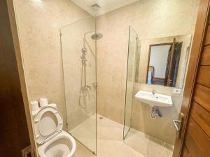 a bathroom with a shower and a toilet and a sink at Made Arsa Homestay in Ubud