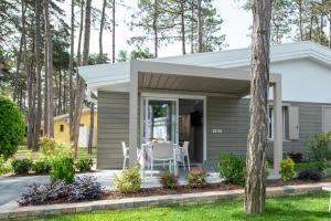 a tiny house with a porch and a table at Villaggio Turistico Internazionale in Bibione