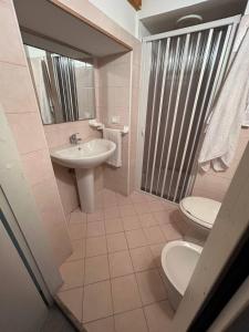 Un baño con lavabo, inodoro y ducha. en La Casa di Modica, en Módica