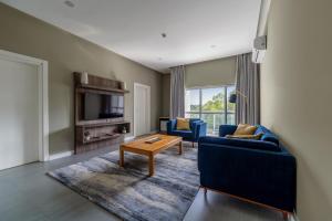 a living room with two blue couches and a table at Central Hotel Ridge in Accra