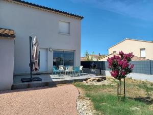 a house with a patio with chairs and a tree at Villa proche d'Avignon in Jonquerettes