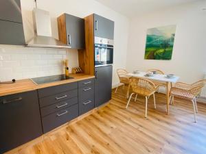 a kitchen and dining room with a table and chairs at Bergluft TOP 1 Modern Apartment with 2 bedrooms 1 hour from Vienna Parking & 24 hour Self Check-in in Grafenbach