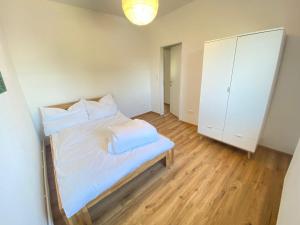 Un dormitorio con una cama con sábanas y almohadas blancas. en Bergluft TOP 1 Modern Apartment with 2 bedrooms 1 hour from Vienna Parking & 24 hour Self Check-in, en Grafenbach