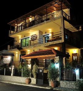 a building with a restaurant with a balcony at night at Guesthouse Chrysa in Kalavrita