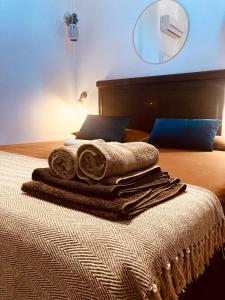 Una cama con toallas y un espejo en la pared. en Domus Mylae, en Milazzo
