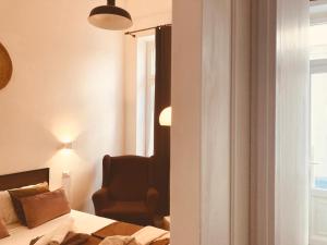 a bedroom with a bed and a chair and a window at Domus Mylae in Milazzo