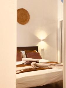Una cama con almohadas marrones y una luz en la pared. en Domus Mylae, en Milazzo