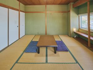 a room with a table in the middle of a room at Guest Living Mu Nanki Shirahama in Shirahama