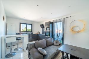 un salon avec un canapé et une cuisine dans l'établissement Bienvenue chez Sandyan- A 15 minutes de la plage, à Rivesaltes