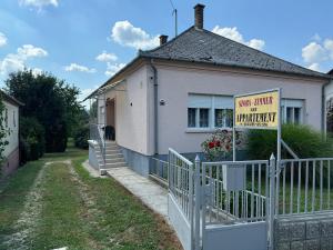 a house with a sign that reads only minute to warranty at Napsugár Vendégház in Kehidakustány