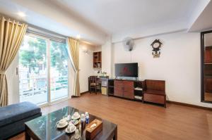 a living room with a couch and a tv at A25 Hotel - 44 H&agrave;ng B&uacute;n in Hanoi
