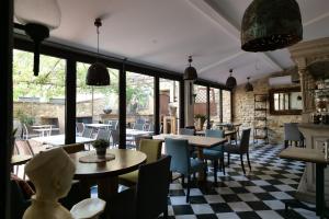 un ristorante con tavoli, sedie e finestre di Chambres du Vieux Bistrot a Cabrières-dʼAvignon