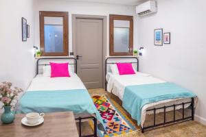 two beds in a room with a table at HB apartments Hill House in Tbilisi City