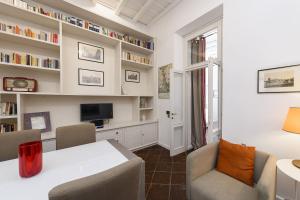 a living room with a table and chairs and a tv at Bernini al Borgo in Rome