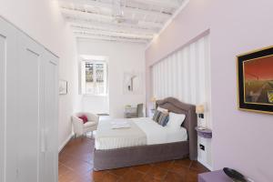 a white bedroom with a bed and a chair at Bernini al Borgo in Rome