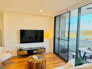 a living room with a flat screen tv on a wall at Harbour Towers, Newcastle's Elite Apartment Stays, Free Parking & Tram Access in Newcastle