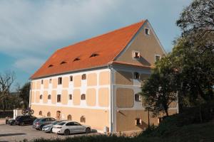 ein großes Gebäude mit auf einem Parkplatz abgestellten Autos in der Unterkunft Granarium in Ilok