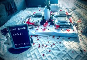 a christmas table with plates and a sign that says happy birthday at 2Bed in exquisite golf estate! in Roodepoort +36 photos