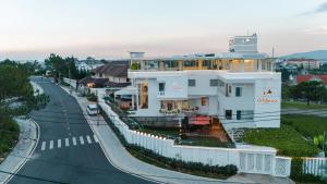 a white building on the side of a road at California Hotel in Da Lat