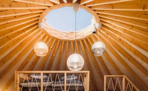 a room in a wooden cabin with a round window at Nálunk, vidéken - Jurta 24 in Ásványráró