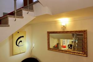 a room with a mirror, a lamp, and a picture on the wall at Hotel Mestre de Avis in Guimarães