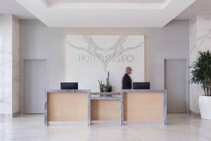 a man standing at a reception desk in a lobby at HOTEL PASEO, Autograph Collection in Palm Desert
