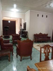 a living room filled with furniture and a piano at Dapugh Ma Roen Guesthouse in Pagaralam