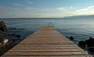 een houten pier in het water bij Skajado Holiday Apartments in Stalida