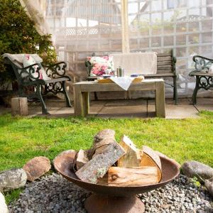 a fire pit in a garden with a bench and a table at 5-Bed Highland Lodge - NC500 - Sleeps 10 in Alness +36 photos