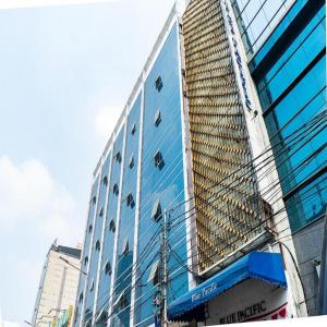a tall blue building with a reflection of a building at RedDoorz Plus at Blue Pacific Blok M in Jakarta
