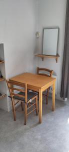 a wooden table and a chair in a room at STUDIO Centre Ville in Aurillac +2 photos