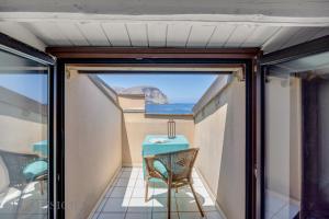 ein Balkon mit Tisch und Meerblick in der Unterkunft Mondello in Terrazza by DomuSicily in Mondello