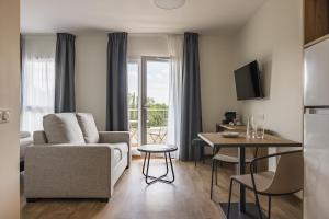un soggiorno con un divano e un tavolo di Hôtel des Thermes des Fumades ad Allegre Les Fumades