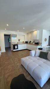 a living room with a white couch and a kitchen at Mas la Rigaude in Livron-sur-Drôme