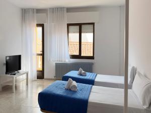 Una habitación de hotel con dos camas y un televisor. en Complejo Tamanaco Illa de Arousa 3000, en A Illa de Arousa