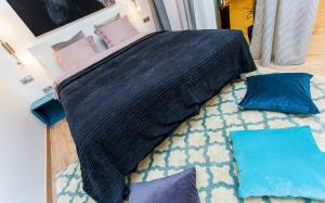 une chambre avec un lit et des oreillers sur un tapis dans l'établissement Laksa Apartments, à Budapest