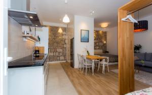 une cuisine et un salon avec une table et des chaises dans l'établissement Laksa Apartments, à Budapest