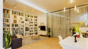un salon avec un grand mur de livres dans l'établissement Laksa Apartments, à Budapest