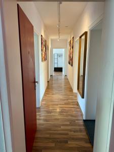 - un couloir dans un immeuble de bureaux doté de parquet dans l'établissement Mickey Flat 3 Zimmer Wohnung in Vohburg mit Büro, à Vohburg an der Donau