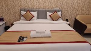 a hotel room with a bed with two remote controls at Hotel Stalwart Jajati in Bhubaneshwar