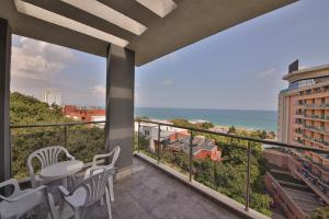 a balcony with a table and chairs and the ocean at Arena Mar Hotel and SPA in Golden Sands